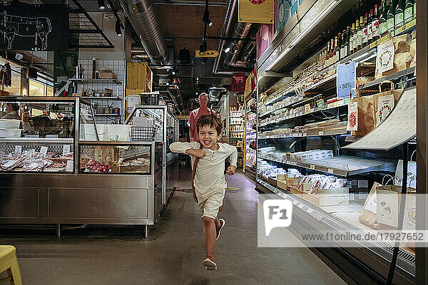 Aufgeregter Junge  der mit seinem Großvater im Supermarkt einkauft