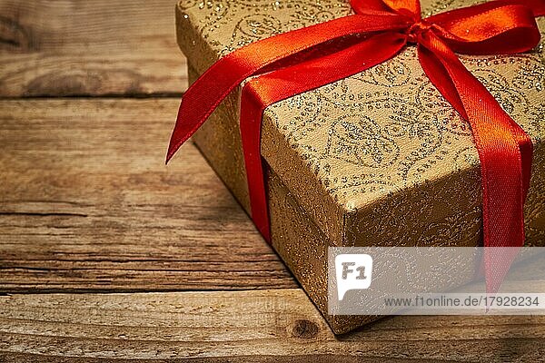 Geschenk Geschenk Geburtstag Weihnachten Konzept  Geschenk-Box mit roter Schleife auf hölzernen Hintergrund Nahaufnahme