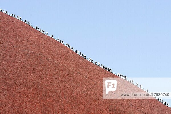 Eine lange Menschenschlange besteigt die steile rote Felswand des Uluru (Ayers Rock)  Australien  Ozeanien