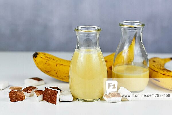 Helathy gelbes Bananen Kokosnuss Smoothie Getränk in Gläsern neben den Zutaten