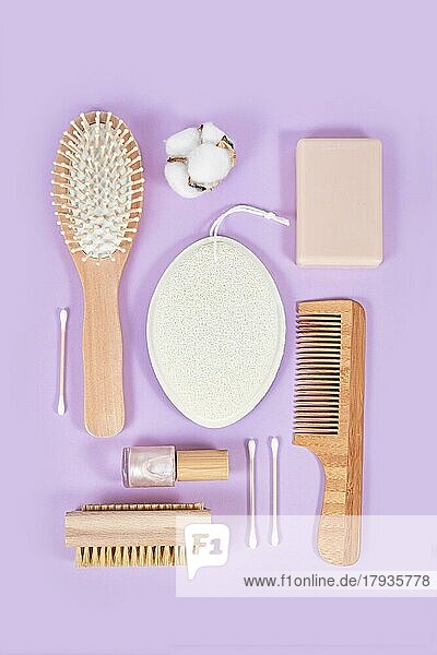 Umweltfreundliche hölzerne Schönheits- und Hygieneprodukte wie Kamm und Seife auf violettem Hintergrund angeordnet