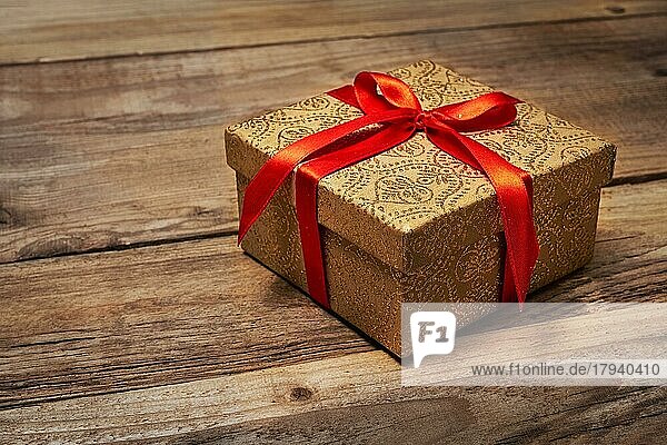 Geschenk Geschenk Geburtstag Weihnachten Konzept  Geschenk-Box mit roter Schleife auf hölzernen Hintergrund