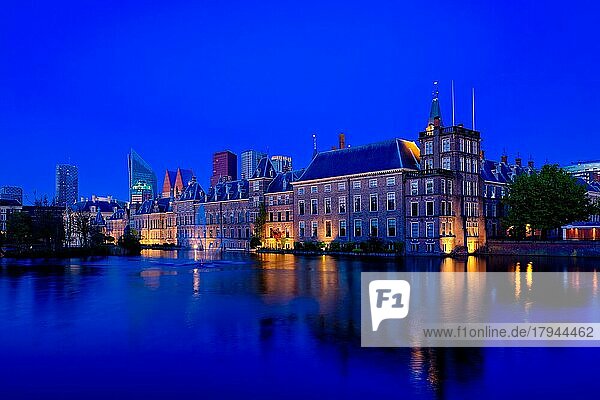 Blick auf den Binnenhof des Parlaments und den Hofvijver-See mit den abendlich beleuchteten Wolkenkratzern der Innenstadt im Hintergrund. Den Haag  Niederlande  Europa
