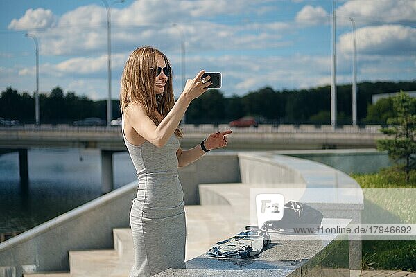 Attraktive Tourist Mädchen macht Selfie mit Flussufer auf Hintergrund in Stadtpark