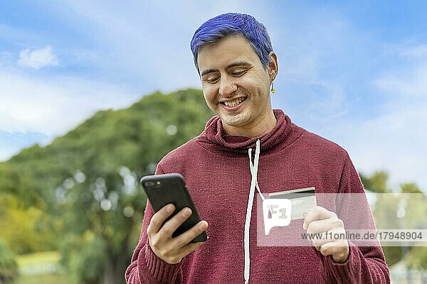 Latin Gay Mann verwendet Kreditkarte  um Online-Zahlung auf Smartphone zu machen. gemischtrassiger Mann verwendet Mobiltelefon für Online-Shopping. Ein Mann benutzt sein Smartphone  um Kreditkartentransaktionen über eine App zu überprüfen. Textfreiraum