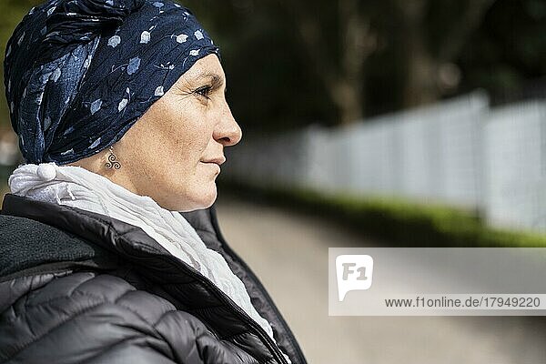 Porträt einer lateinamerikanischen Frau  die sich einer Krebsbehandlung unterzieht und ihren Kopf mit einem Schal bedeckt  der einen Ausdruck von Stärke vermittelt