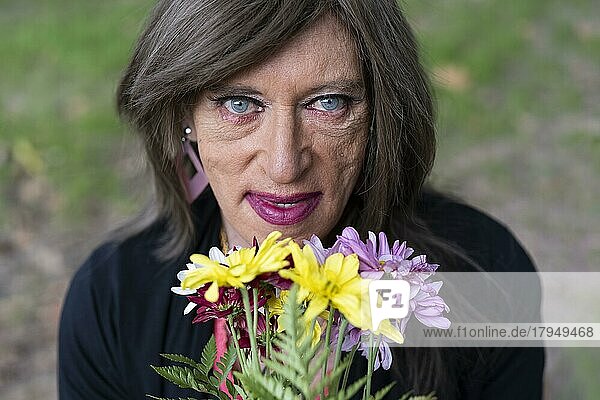 Porträt einer reifen Transgender-Frau mit einem Blumenstrauß von oben gesehen