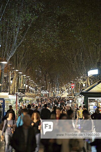 Touristen besuchen die Straße La Rambla bei Nacht in Barcelona. La Rambla ist bei Touristen und Einheimischen gleichermaßen beliebt  Barcelona  Spanien  Europa