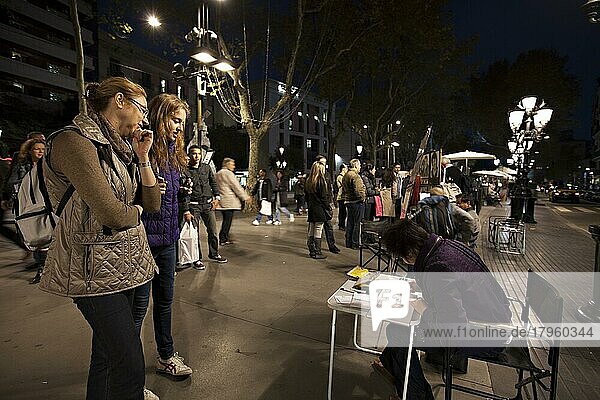 Touristen beobachten Kunstwerker in der Straße La Rambla bei Nacht in Barcelona. La Rambla ist bei Touristen und Einheimischen gleichermaßen beliebt  Barcelona  Spanien  Europa