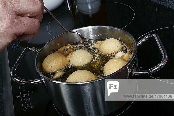Schwäbische Küche  Versoffene Jungfern  Süßspeise  Zubereitung von Fettgebackenem  heißes Öl in einem Topf  Teig ausbacken  Männerhände  Deutschland  Europa