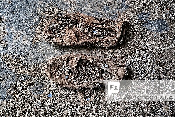 Verrottete Espandrillas  Fragment von Freizeitschuh auf dem Boden  verrottete Schuhe am Boden  verrotteter Schuh  Schuhwrack  vergammelter Treter  ausgelatschter Schuh  abgetragener Schuh