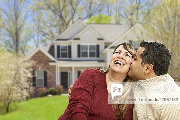 Glückliches gemischtrassiges Paar vor einem schönen Haus