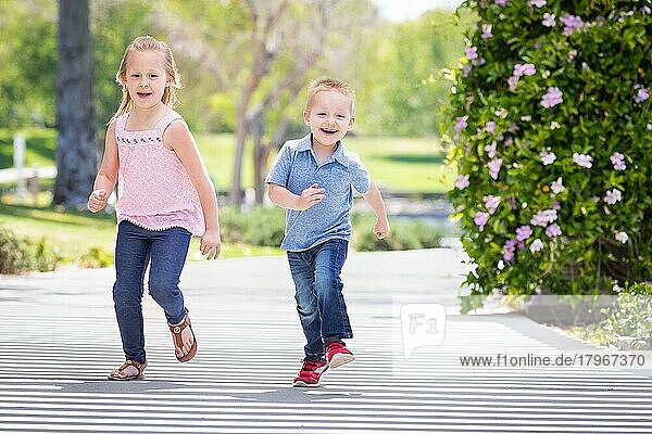 Junge Schwester und Bruder haben Spaß beim Laufen im Park