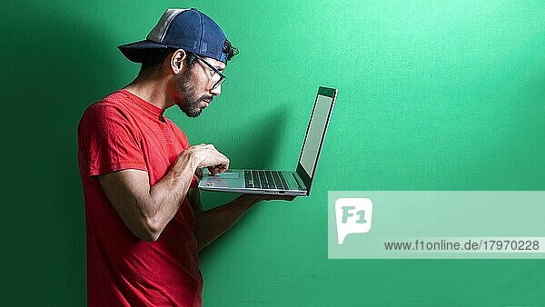 Kerl mit Mütze überprüft seinen Laptop isoliert  überraschter Mann überprüft seinen Laptop