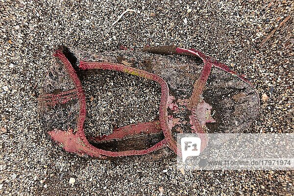 Fragment von Hausschuh am Strand  maroder Hausschuh am Boden  verrotteter Schuh  Schuhwrack  vergammelter Treter  ausgelatschter Schuh  abgetragener Schuh