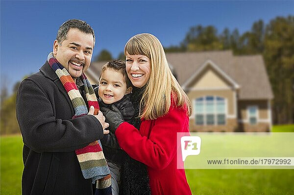 Glückliche junge gemischtrassige Familie vor einem schönen Haus