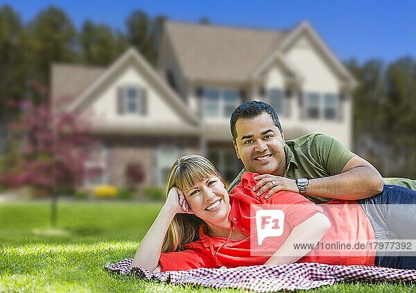 Glückliches gemischtrassiges Paar vor einem schönen Haus