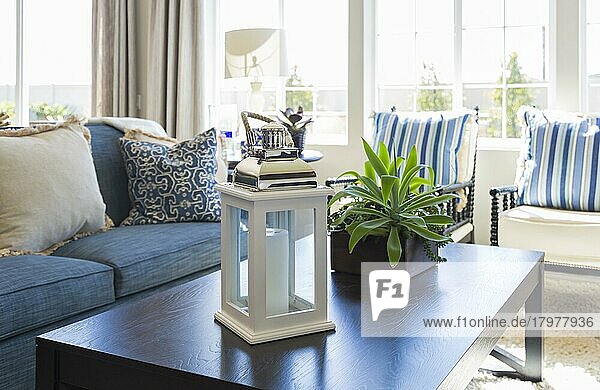 Schöner blau akzentuierter Wohnbereich mit Couchtisch  Couch und Stühlen von Zuhause