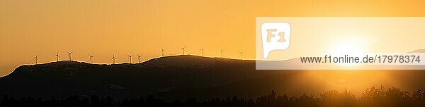 Windkraftanlagen  Dramatischer Silhouetten-Sonnenuntergang über den Lavanttaler Alpen in der Steiermark  Steirische Alpen im orangefarbenen Licht des Sonnenuntergangs  Österreich  Europa