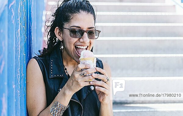 Urbanes Mädchen ißt eine Eiswaffel  Ein Mädchen ißt ein Eis im Freien  Mädchen genießt ein Eis  Nahaufnahme einer Frau mit einem Eis