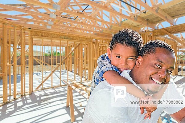 Junger afroamerikanischer Vater und gemischtgeschlechtlicher Sohn auf der Baustelle in ihrem neuen Haus  das im Rohbau steht