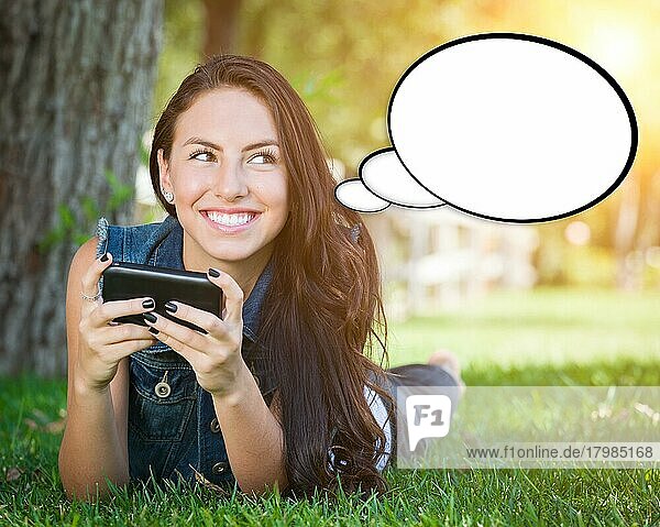 Nachdenkliche junge Frau mit Handy und leerer Gedankenblase
