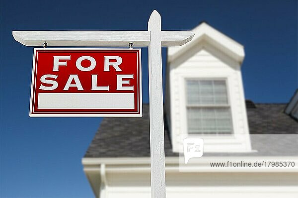 Links zu verkaufen Immobilien Schild vor dem Haus und tiefblauen Himmel