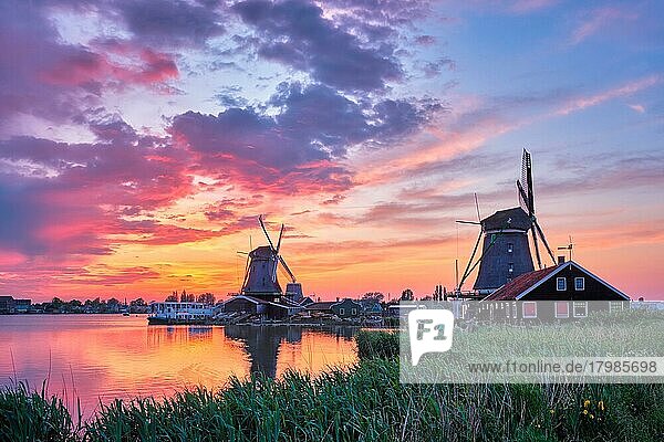 Ländliche Szene in den Niederlanden  Windmühlen am berühmten Touristenort Zaanse Schans in Holland bei Sonnenuntergang mit dramatischem Himmel. Zaandam  Niederlande  Europa