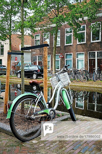 Netherlands popular means of transport bicycle parked near the canal in Delft street with old houses. Delft  Netherlands