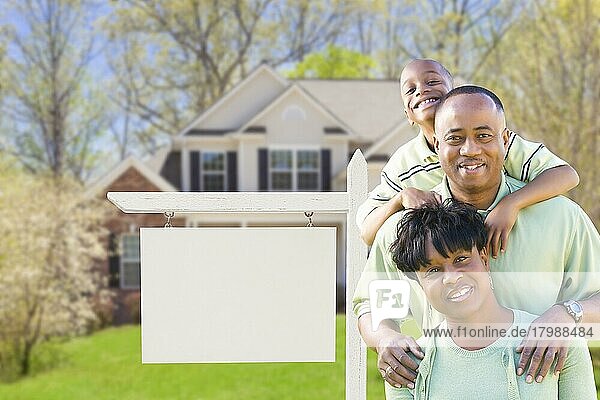 Afroamerikanische Familie vor einem leeren Immobilienschild und einem neuen Haus  Textfreiraum