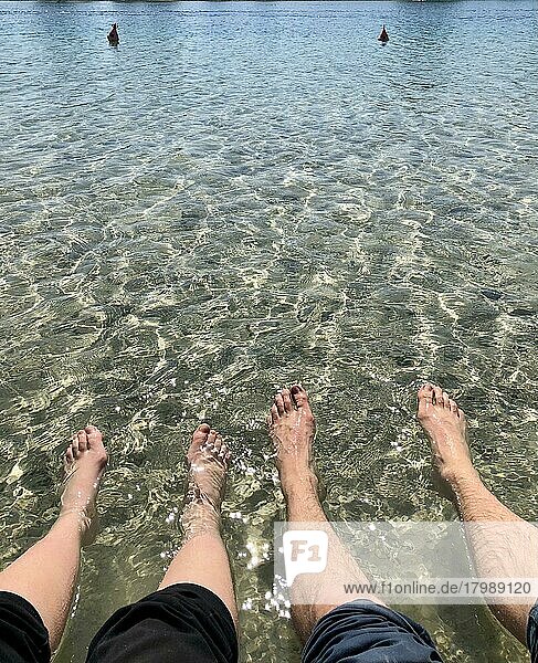 Two pairs of feet in the water  bathing in the lake  Riemer See  Munich  Bavaria  Germany  Europe