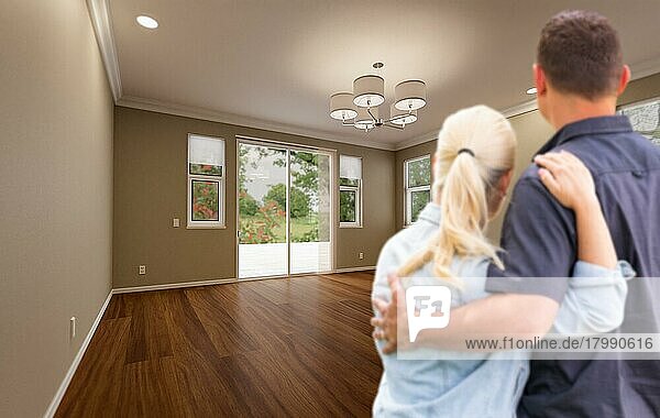 Junges erwachsenes Paar betrachtet ein leeres Zimmer in einem neuen Haus