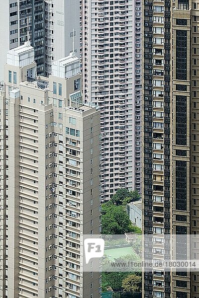 Blick auf kleinen Garten und Tennisplatz zwischen Wolkenkratzer-Wohnblöcken in dicht besiedeltem Stadtgebiet  Hongkong  China  Asien