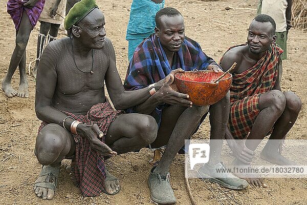 Nyangatom-Männer teilen sich eine Kalebasse mit Kuhblut  Omo-Flusstal  Äthiopien  Bume  Buma  Bumi  Afrika