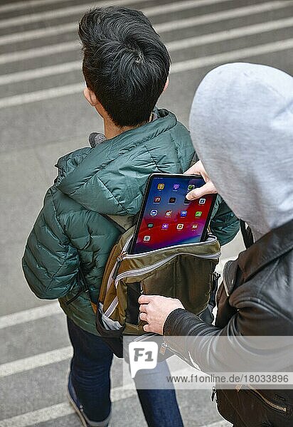 Diebstahl eines Tablets aus einem Rucksack  Strassenkriminalitaet  gestelltes Foto