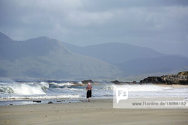 Woman walks Rennvyle Beach along Wild Atlantic way in summer. County Galway  Ireland  Europe
