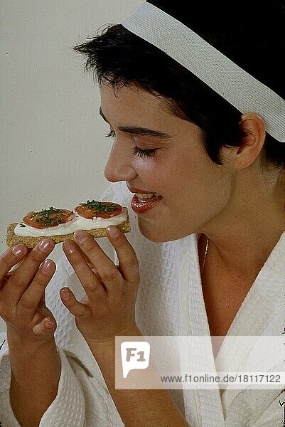 Junge Frau ißt Knäckebrot mit Quark und Tomate  leicht genießen  Diät  Schlank