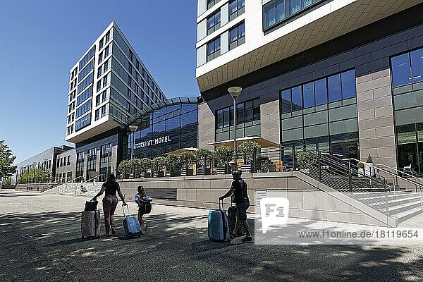 Familie mit Rollkoffer geht zum Maritim Hotel am Flughafen  Düsseldorf  Nordrhein-Westfalen  Deutschland  Europa