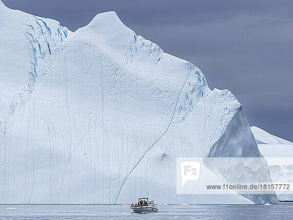 Touristen  die eine Eistour in einem kleinen Boot unternehmen und Eisberge vom Ilulissat-Eisfjord aus beobachten  kurz vor Ilulissat  Grönland  Dänemark  Polarregionen