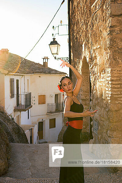 Woman dancing flamenco in an old street at sunset