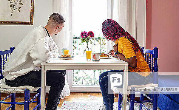 Multiracial couple having breakfast at home