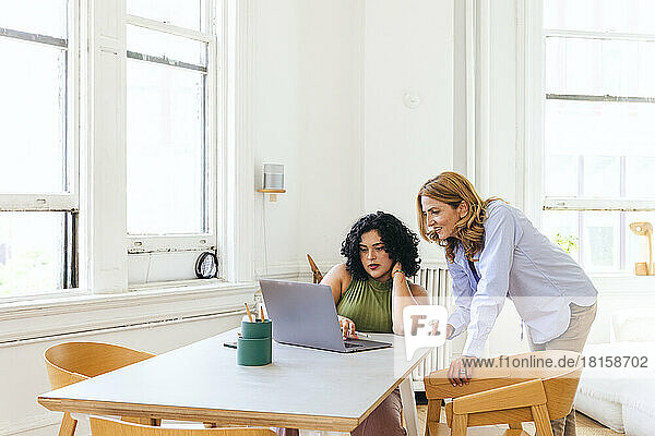 Kreative Geschäftsfrauen  die in einer Sitzung über Laptop eine Strategie diskutieren