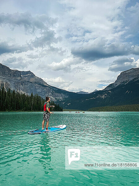 Teen paddling SUP on Emerald Lake in Yoho National Park  Canada.