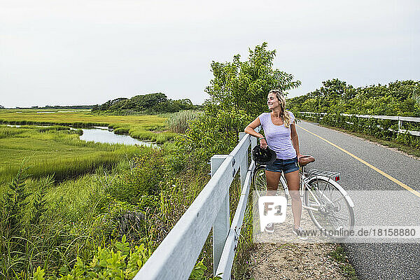 Frau rastet auf dem Radweg durch die Cape Cod Marshes