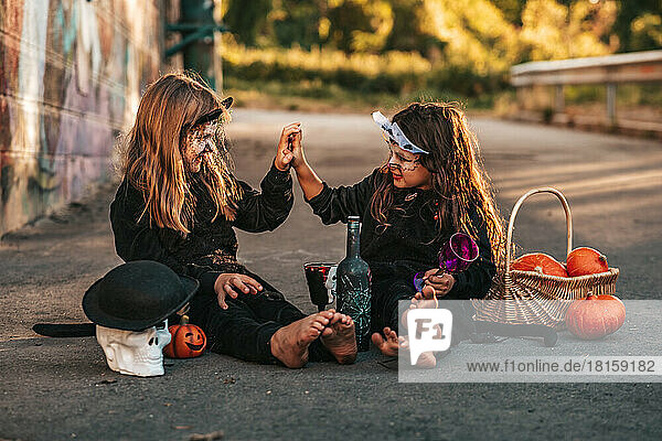 zwei kleine Mädchen  die als schwarze Katzen verkleidet eine Halloween-Party feiern