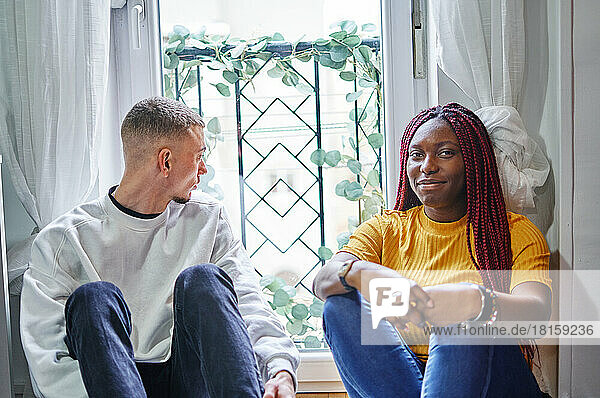 Glückliche afrikanische Freundin und Freund im Gespräch zu Hause