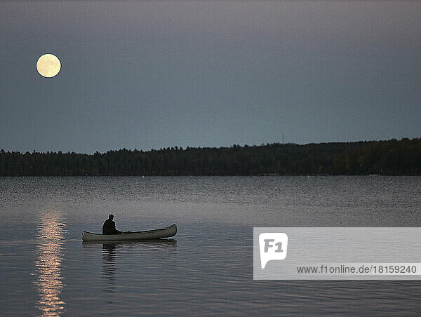 Einsames Paddeln im Kanu bei Vollmond auf dem Sebec Lake in Maine