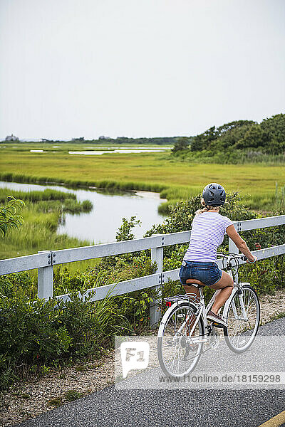 Junge Frau radelt durch Cape Cod Marshes Radweg