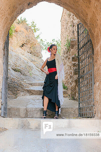 Frau im Flamenco-Kleid am Eingang einer alten Burg