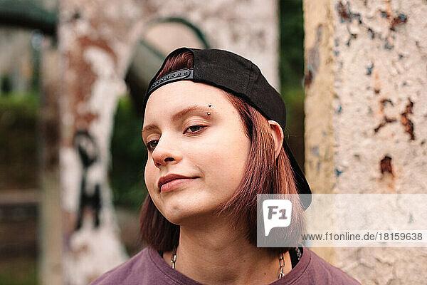 Porträt eines punkigen Teenagers mit gepiercter Augenbraue und verkehrter Mütze